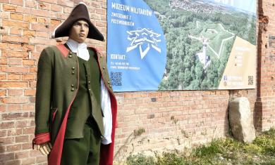 tekst alternatywny: manekin, a za nim baner z napisem fort prusy. 