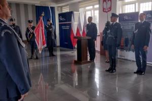 Zdjęcie wykonano w świetlicy jednostki w czasie uroczystej odprawy z okazji Święta Służby Więziennej. Przedstawia umundurowanych funkcjonariuszy uczestniczących w uroczystości. 
