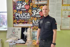 Na zdjęciu funkcjonariusz Służby Więziennej po lewej stronie na stoliku przedmioty przekazane na licytację 32 Finału Wielkiej Orkiestry Świątecznej Pomocy.
