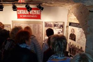 Grupa osób zwiedzajaca historyczne  podziemia Zakładu Karnego. 
